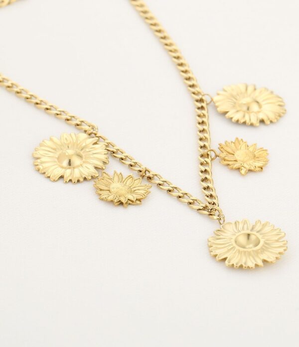 Straal als de zon met de Sunlit Charm Ketting. Deze prachtige gouden ketting is versierd met delicate zonnebloem- en madeliefjesbedels die een vleugje natuurlijke elegantie toevoegen aan je outfit. Het robuuste schakeldesign zorgt voor een trendy uitstraling, terwijl de bloemencharms een vleugje speelsheid brengen. Perfect te dragen als statement piece of om een zomerse flair toe te voegen aan elke look. Laat je stijl bloeien!