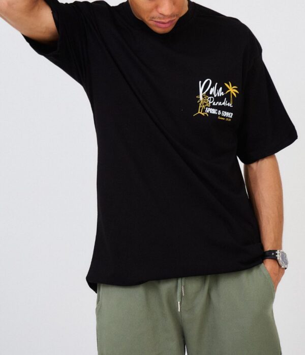 Laat je meevoeren naar tropische vibes met het Palm Paradise T-Shirt in zwart. Dit shirt combineert een ontspannen stijl met een vleugje avontuur, dankzij het subtiele palmboomprintontwerp. Gemaakt van zacht, ademend katoen, biedt het ultiem draagcomfort, of je nu onderweg bent of gewoon chillt. De minimalistisch zwarte basis zorgt voor veelzijdigheid, waardoor het perfect te combineren is met jeans, shorts of een jogger. Een must-have voor elke casual outfit!